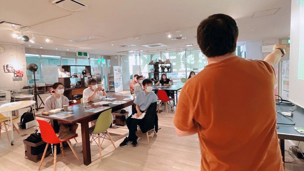 ワークショップで参加者に向かって話すTenさんの後ろ姿