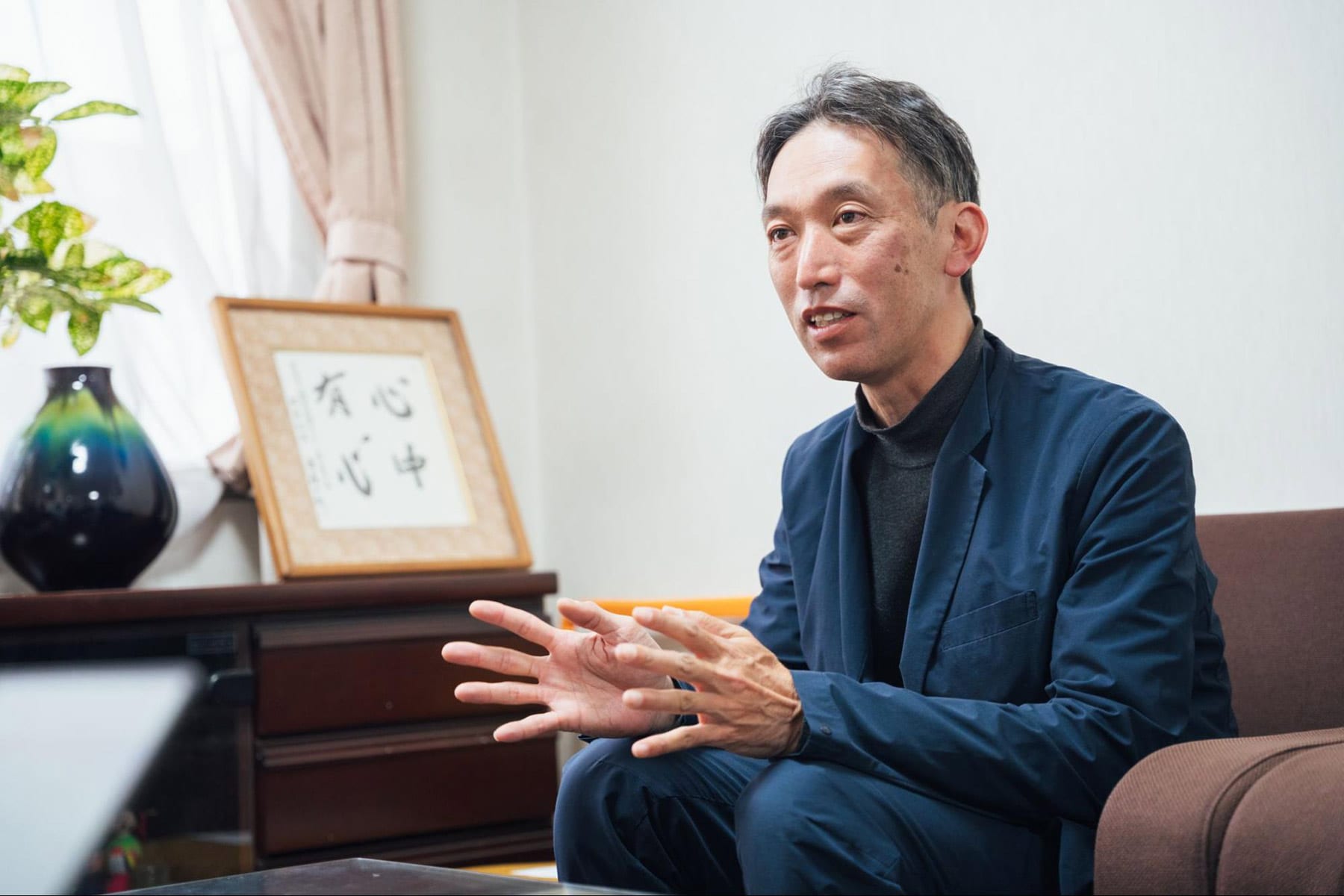 ソファーに腰掛けて話す伊吾田さん