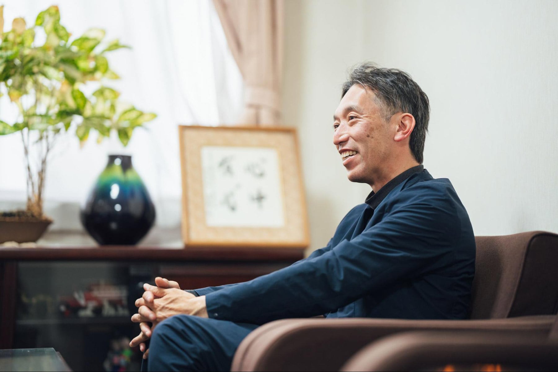 ソファーに腰掛けて笑顔で話す伊吾田さんの横顔